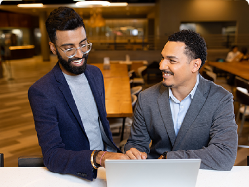 Two SCU students at a laptop having a discussion