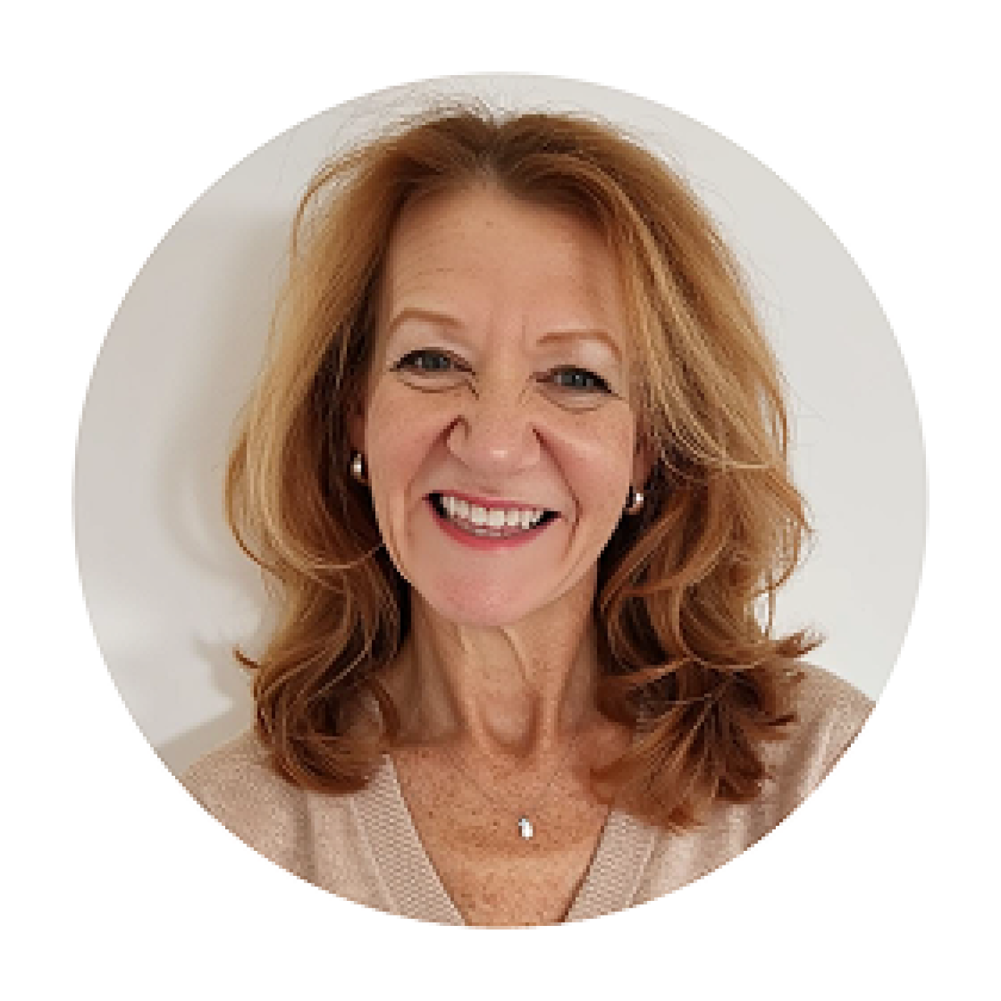 Headshot of Beth Hollenberg, smiling with shoulder-length red hair, wearing a beige top and necklace against a white background.