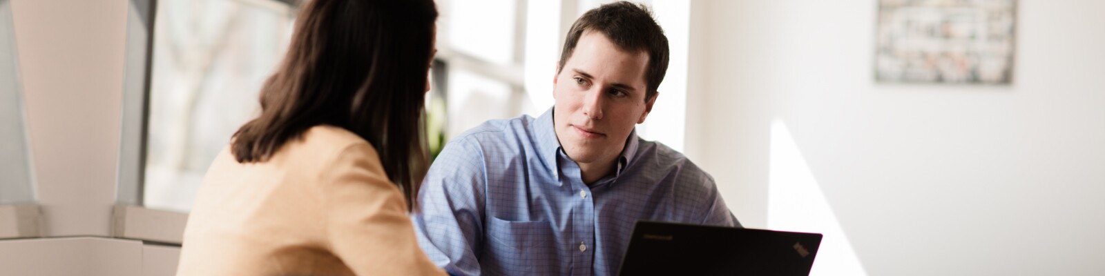 Marquette graduate student speaks to another student in a conference room