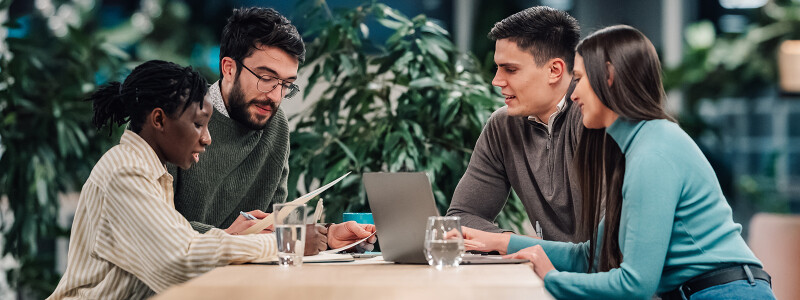 Colleagues discuss marketing strategy around a table