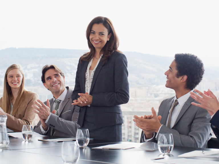 Five Professionals Standing In Group In A Hallway Dark Clothes