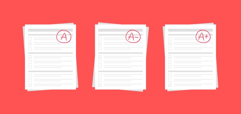 Three student papers with the grades A, A-, and A+ marked on them.