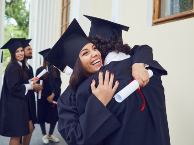 A girl hugging someone after graduating and receiving her diploma