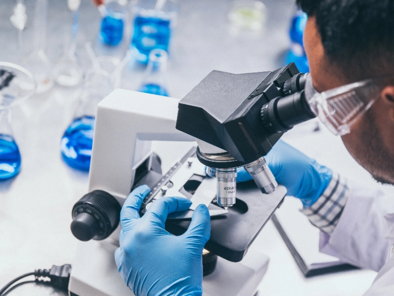 Biostatistician man working at a microscope