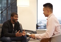 Two men sitting down talking to each other