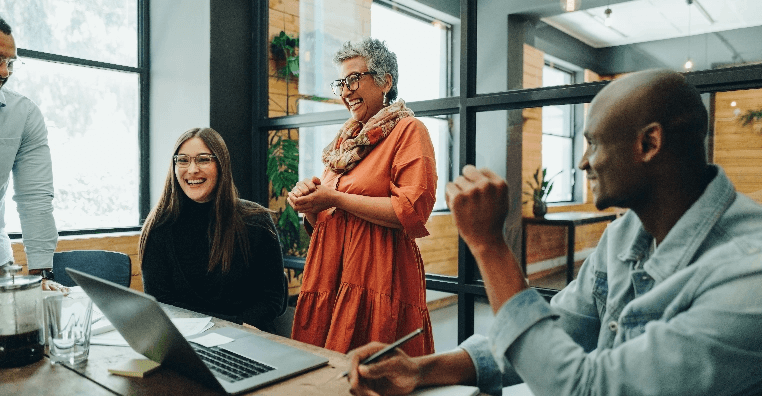 Woman standing and laughing in conference room with colleagues