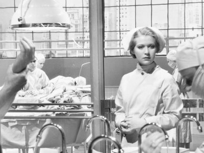 Vintage photo of two surgeons and a nurse in the scrub room preparing for an operation.