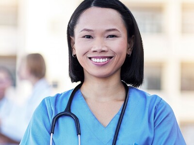 Nurse manager standing in front with her team behind her.