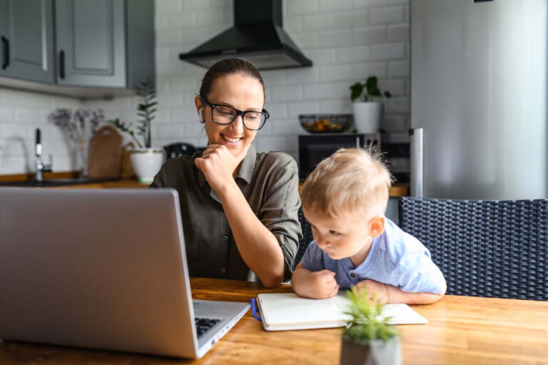 Mom at laptop sitting next to young son