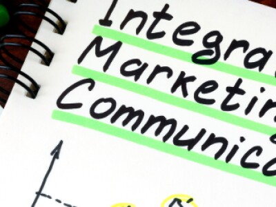 Integrated marketing communication is written in marker on a notebook, with the other words team and strategy