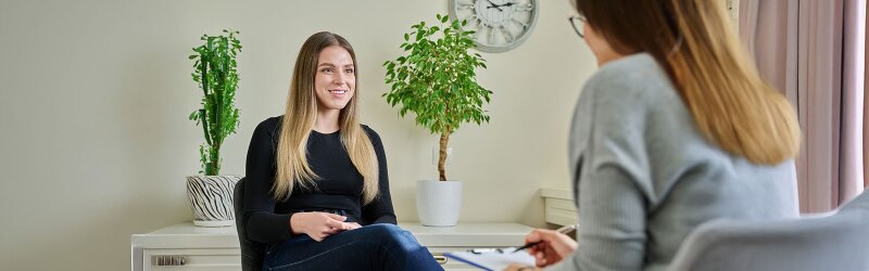 counselor taking notes while in session with young white female client