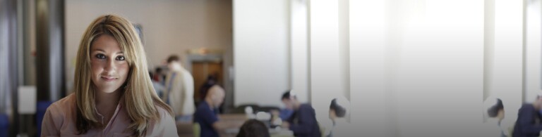 woman in pink shirt smiling while standing in law library