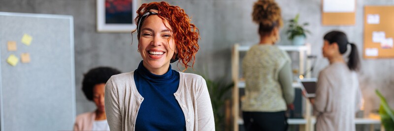 Woman smiling in office among colleagues