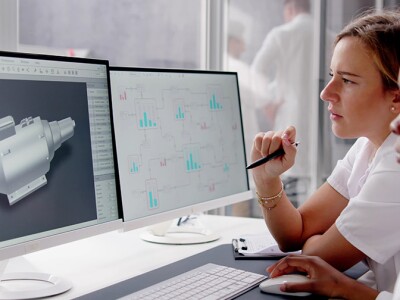 Mechanical engineers designing machine parts on a computer