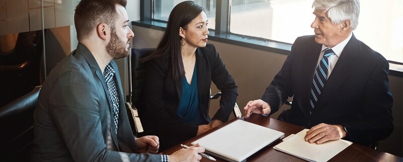 Business professionals in a meeting discussing compliance policies and organizational risk management.