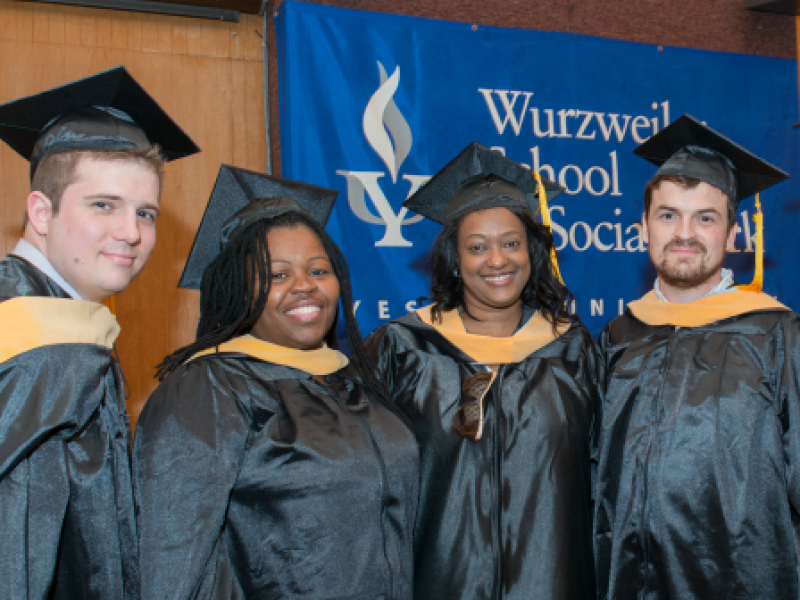 a group of graduates standing in front of a banner