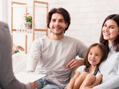 Two parents and a child interacting with a counselor