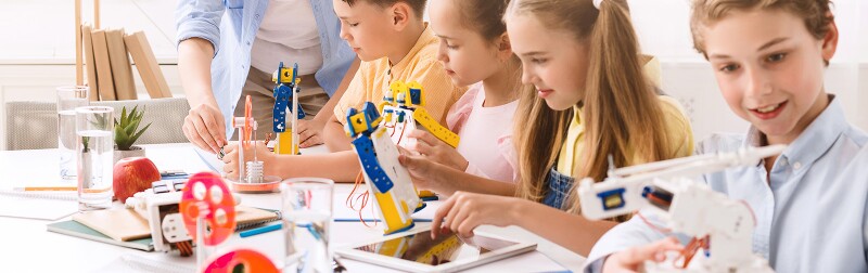 Young students build robots with an adult helping.jpg
