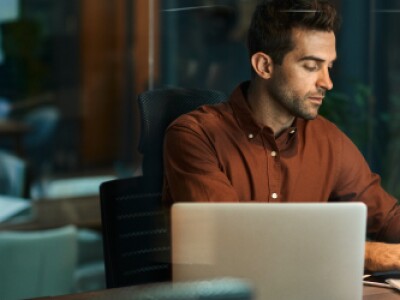 man working on computer at desk at night