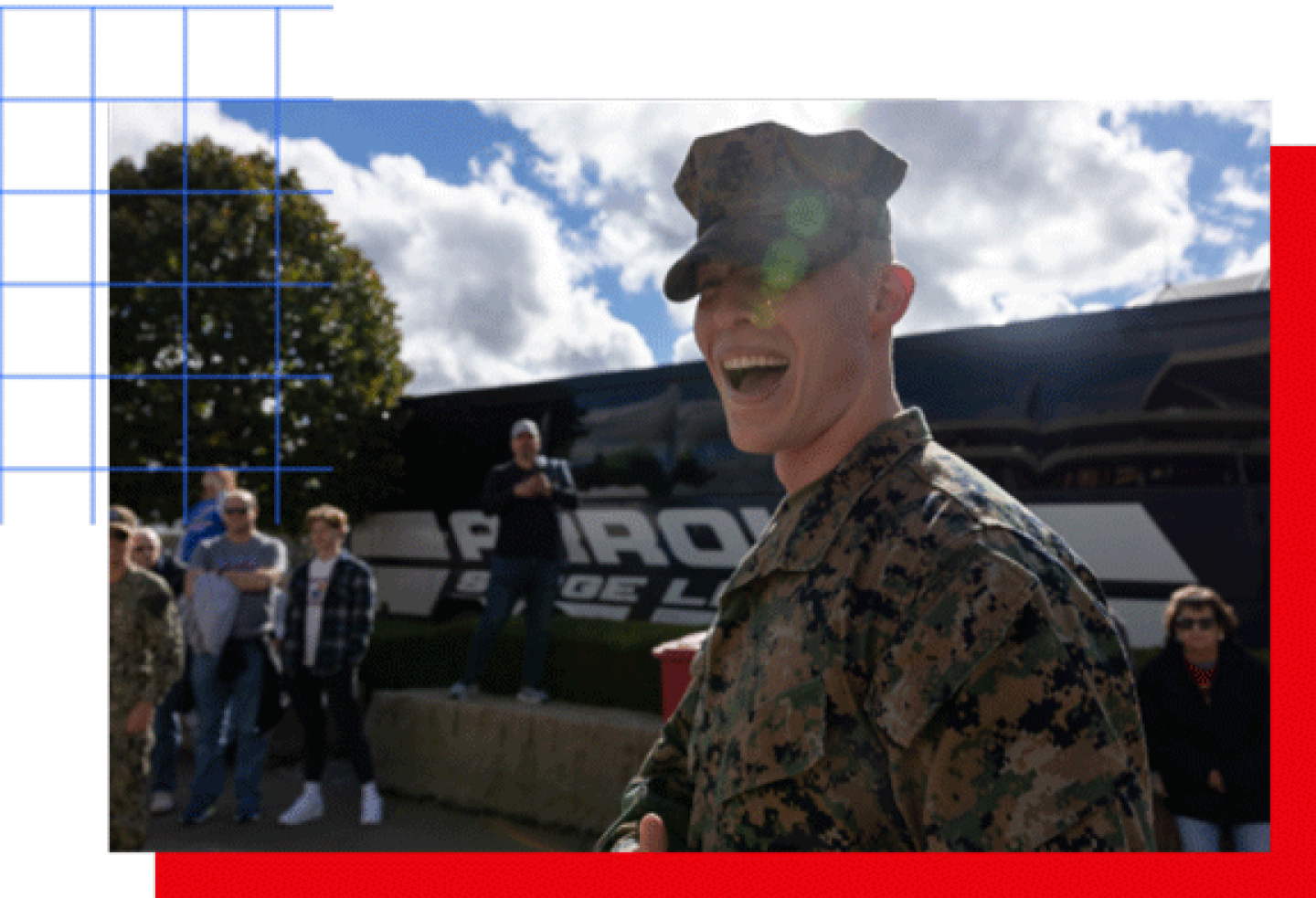 A male service member smiles while standing in front of a bus.
