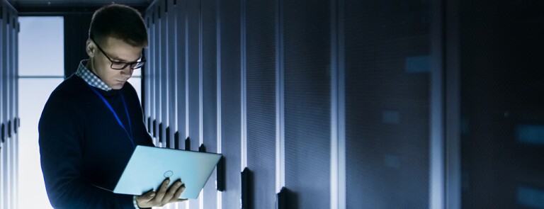 man-on-laptop-in-server-room