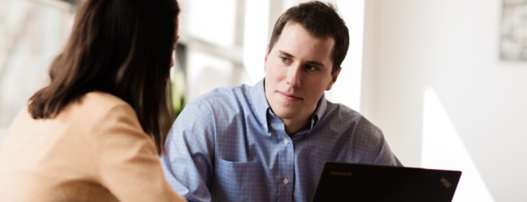 Marquette graduate student speaks to another student in a conference room
