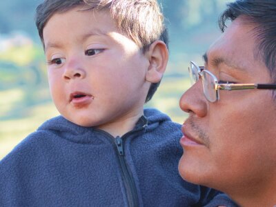 Native american man with his little son in the countryside.
