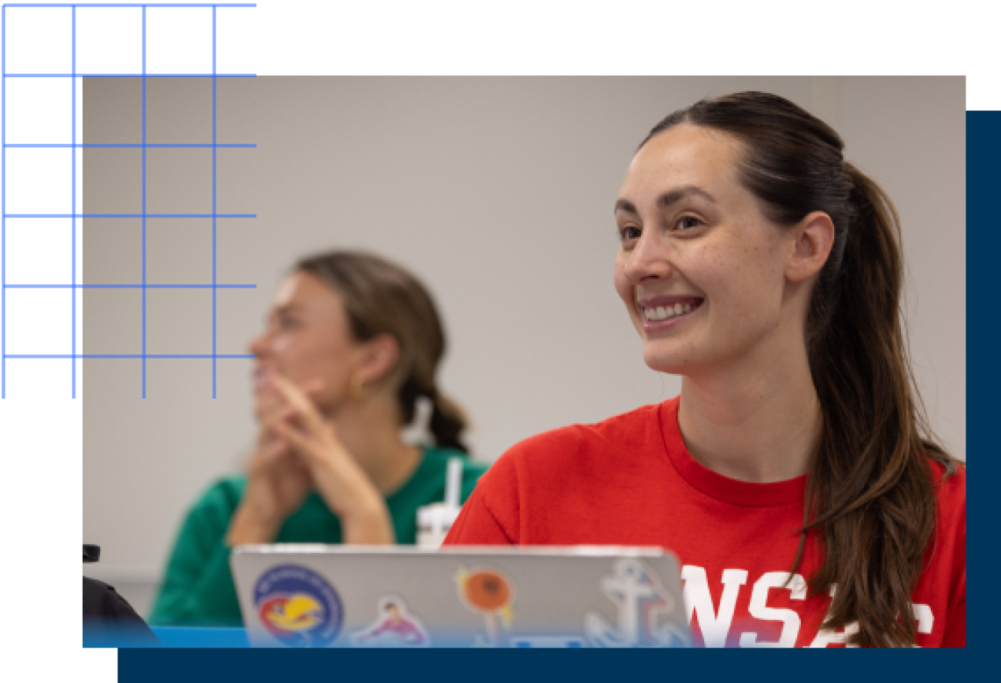 A close-up of a smiling female KU student in a classroom.