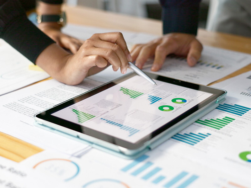 Marketing professionals reviewing digital analytics data on a tablet and printed reports