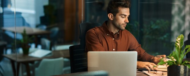 man working on computer at desk at night