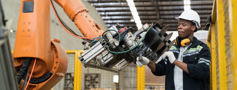 man working on robotic arm for manufacturing