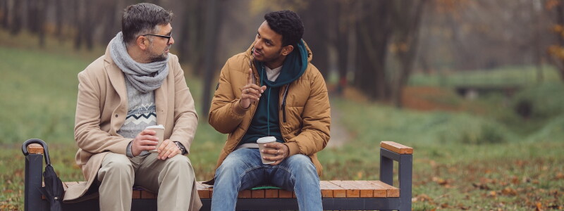 A counselor and client have a thoughtful conversation outdoors.