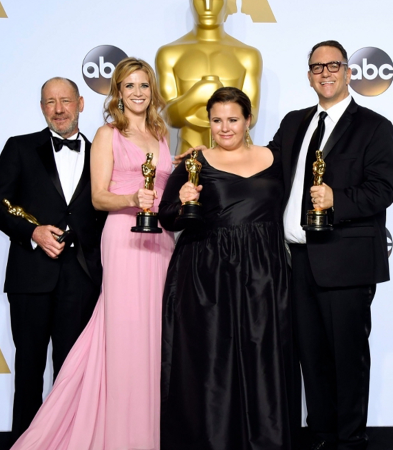 Group of four people on Oscars red carpet holding their awards