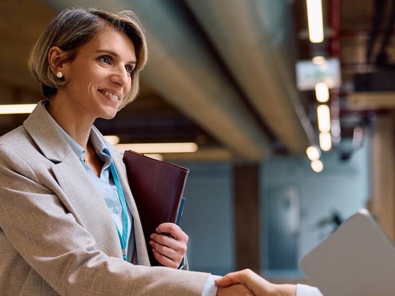 A health services administration professional and a healthcare provider shake hands.