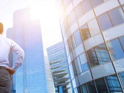 Business man stands downtown reflecting on his career options.