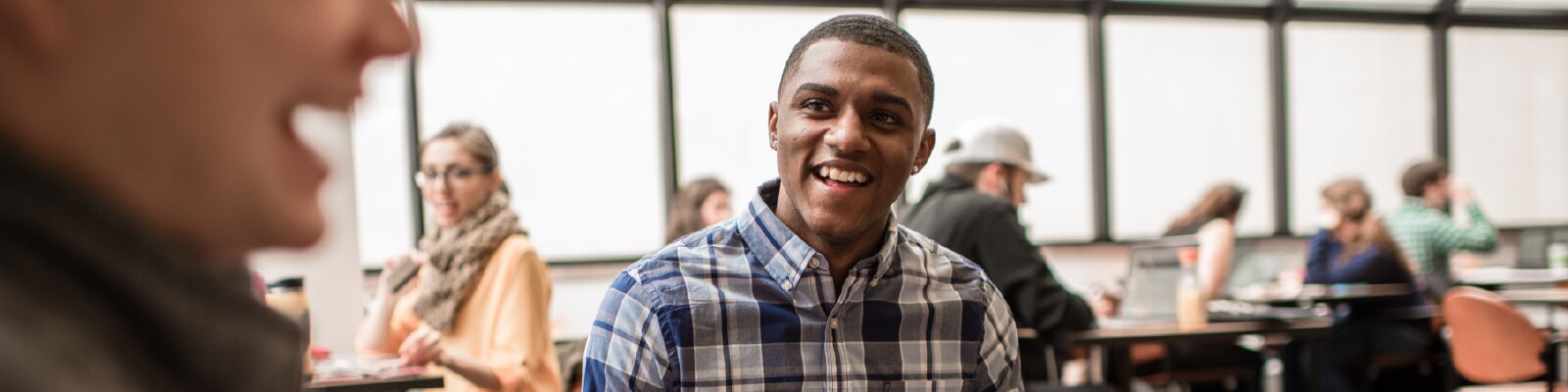 Smiling Marquette student sits in the student common area in a group