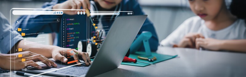 Young students working with computer and tools