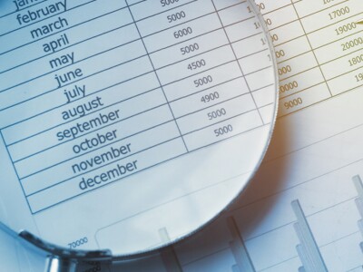 Financial documents with calculator, pen and magnifying glass