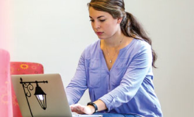 woman with ponytail working on laptop computer
