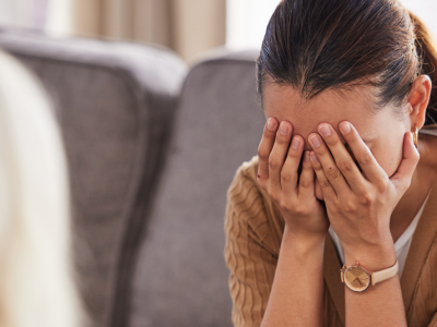 adult covering face while talking to therapist