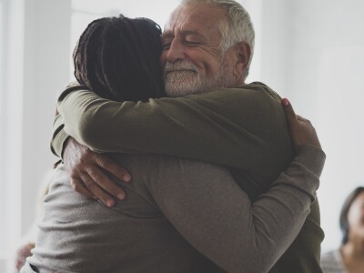 counselor and patient hugging in group therapy