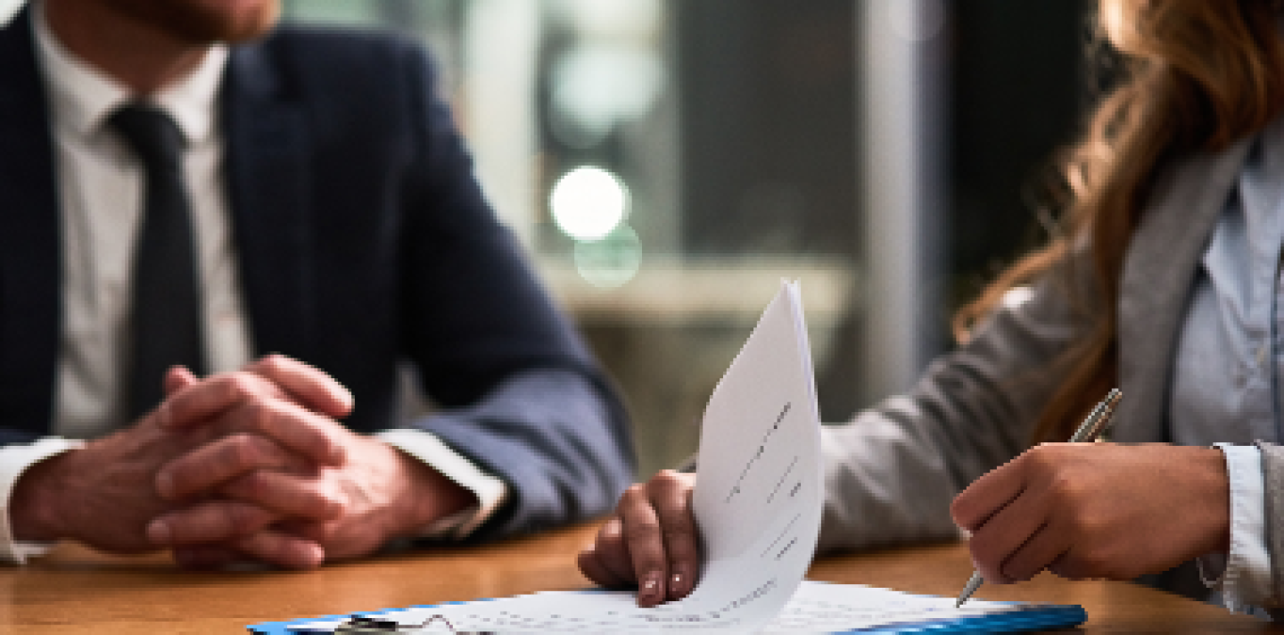 two business professionals at a table with paperwork