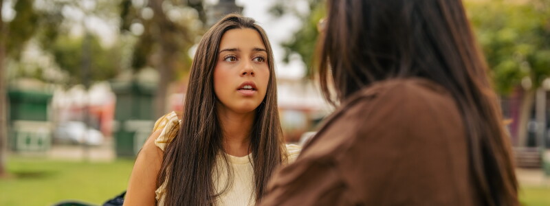 Teenager talking with a counselor outdoors.