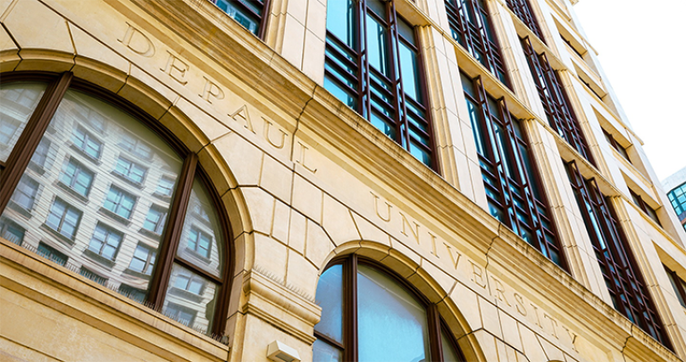 DePaul University building facade with arched windows and engraved stone lettering on exterior