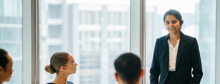 Diverse team in downtown office holds meeting at table