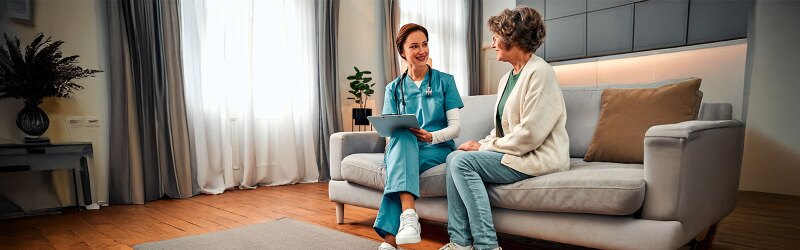 geriatric care nurse sitting in session with elderly female patient