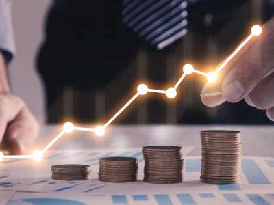 Man stacking coins with a graph of profit.