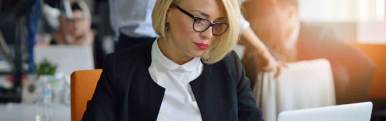 Concentrated businesswoman focused on laptop in office environment