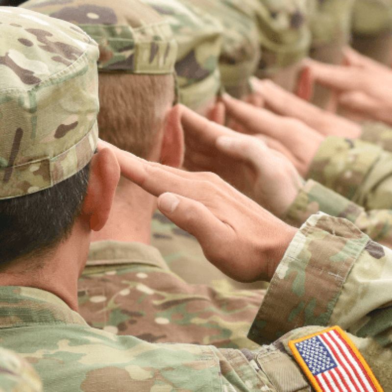 A line of army soldiers in uniform saluting