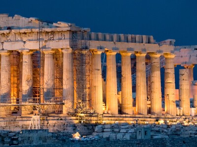 Image of the Parthenon lit up at night.